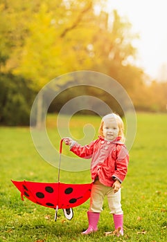 Happy baby holding red umbrella