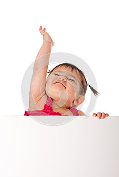 Happy baby holding white board and reaching up