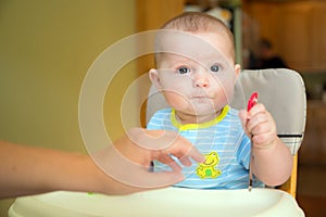 Happy baby infant boy eating meal