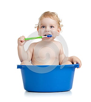 Happy baby kid brushing teeth in basin