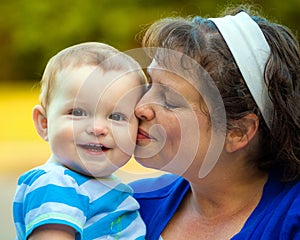 Happy baby kissed by mom photo