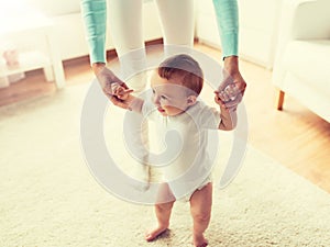 Happy baby learning to walk with mother help