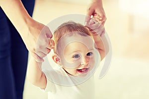 Happy baby learning to walk with mother help