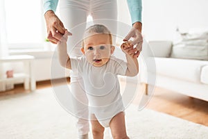 Happy baby learning to walk with mother help