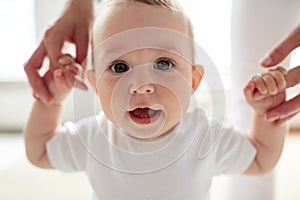 Happy baby learning to walk with mother help