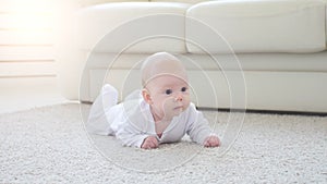 Happy Baby Lying on Carpet Background, Smiling Infant Kid girl in White Clothing