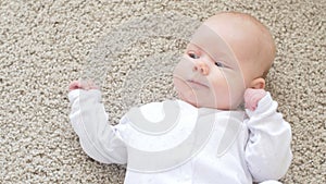 Happy Baby Lying on Carpet Background, Smiling Infant Kid girl in White Clothing