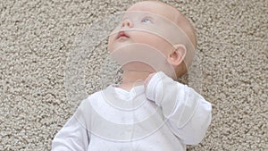 Happy Baby Lying on Carpet Background, Smiling Infant Kid girl in White Clothing