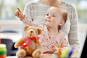 Happy baby with mother working at home office