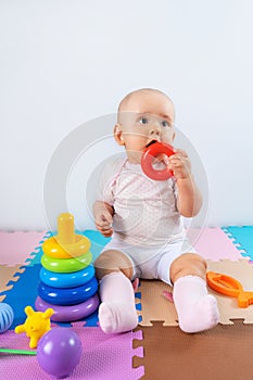 Happy baby is playing with a toy pyramid. Educational toys for toddlers