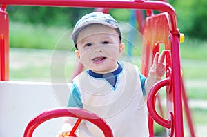 Happy baby plays on playground outdoors