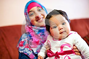 Happy, baby and portrait of muslim mom in home with love and care for family in Saudi Arabia. Infant, child and Arabic