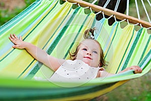 Happy baby is relaxing in a hammock during summer