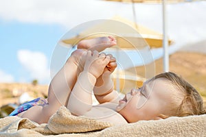 Happy baby resting on the beach sunbed.