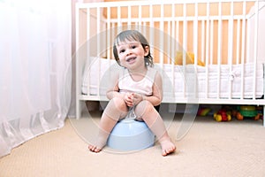 Happy baby sitting on potty photo