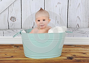 Happy baby sitting in washtub