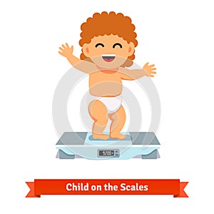 Happy baby toddler in diaper weighting on a scales