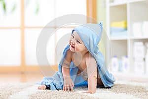 Happy baby in towel crawling on floor at home