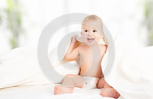 Happy baby under a blanket laughing