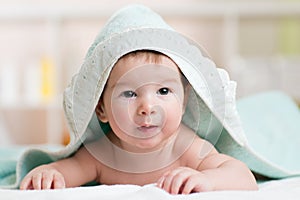 Happy baby under towel indoor