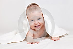 Happy baby under white blanket photo