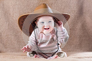 Happy baby wearing cow girl outfit with big hat
