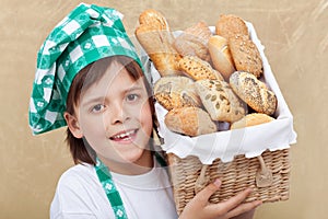 Happy baker boy holding basket with fresh bakery products