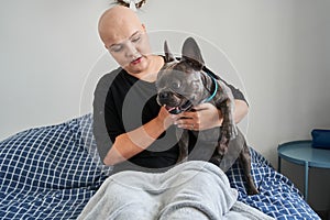 Happy bald woman is enjoying time together with her dog