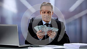 Happy banker counting money, successful investment, profitable deal concept photo