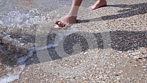 Happy barefoot child have fun on beach walk. Girl run along sea surf by water pool and jump with splashes. Summer