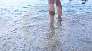 Happy barefoot child have fun on beach walk. Girl run along sea surf by water pool and jump with splashes. Summer
