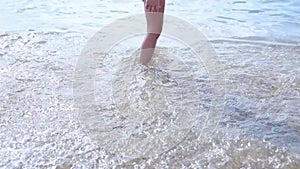 Happy barefoot child have fun on beach walk. Girl run along sea surf by water pool and jump with splashes. Summer