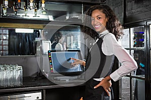 Happy barmaid preparing a bill