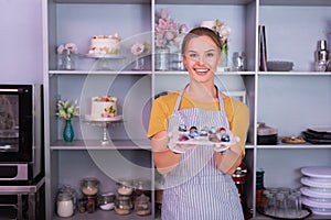 Happy beaming confectioner feeling proud of her perfect chocolates