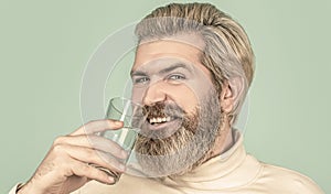 Happy beard man drinking water. Smiling male holding transparent glass in her hand