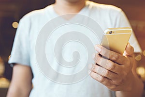 Happy bearded African businessman using phone while sitting on sofa