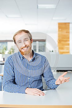 Happy bearded businessman talking and smiling in office