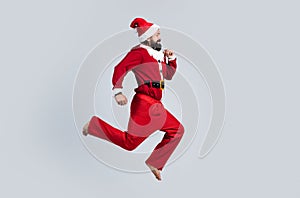 Happy bearded hipster in red santa claus costume running and feel happiness about christmas shopping sales, new year
