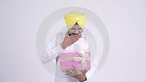 Happy bearded Indian Sikh businessman opening gift box