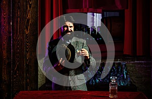 Happy bearded man with glass of brandy or whiskey. Bearded hipster in bar.