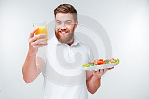 Happy bearded man having healthy snack with vegetables
