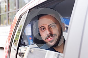 Happy bearded man looking through window in back seat of car. Concept of transport service, journey, motivation