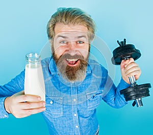 Happy bearded man with milk and dumbbell. Protein cocktail and diet. Vitamins for muscles. Healthy lifestyle.