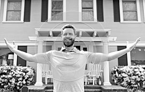 happy bearded man owner near new house after rent or buy new home, ownership