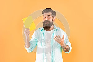 happy bearded man presenting book on yellow background, advertisement