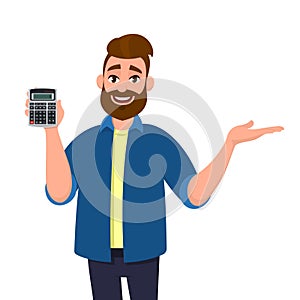 Happy bearded man showing or holding digital calculator device in hand and pointing, presenting something to copy space.