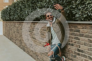 Happy, bearded man taking a selfie with his mobile phone