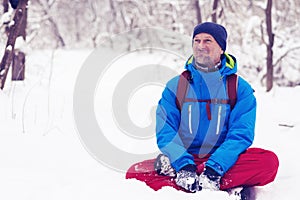 Happy bearded man, traveler relaxing in the winter forest