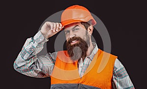 Happy bearded man wears helmet isolated on black background. Engineer or architect smiles. Building, happiness