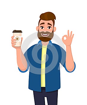 Happy bearded trendy man holding a coffee cup and showing, gesturing or making okay, OK sign with hand fingers. Male character.